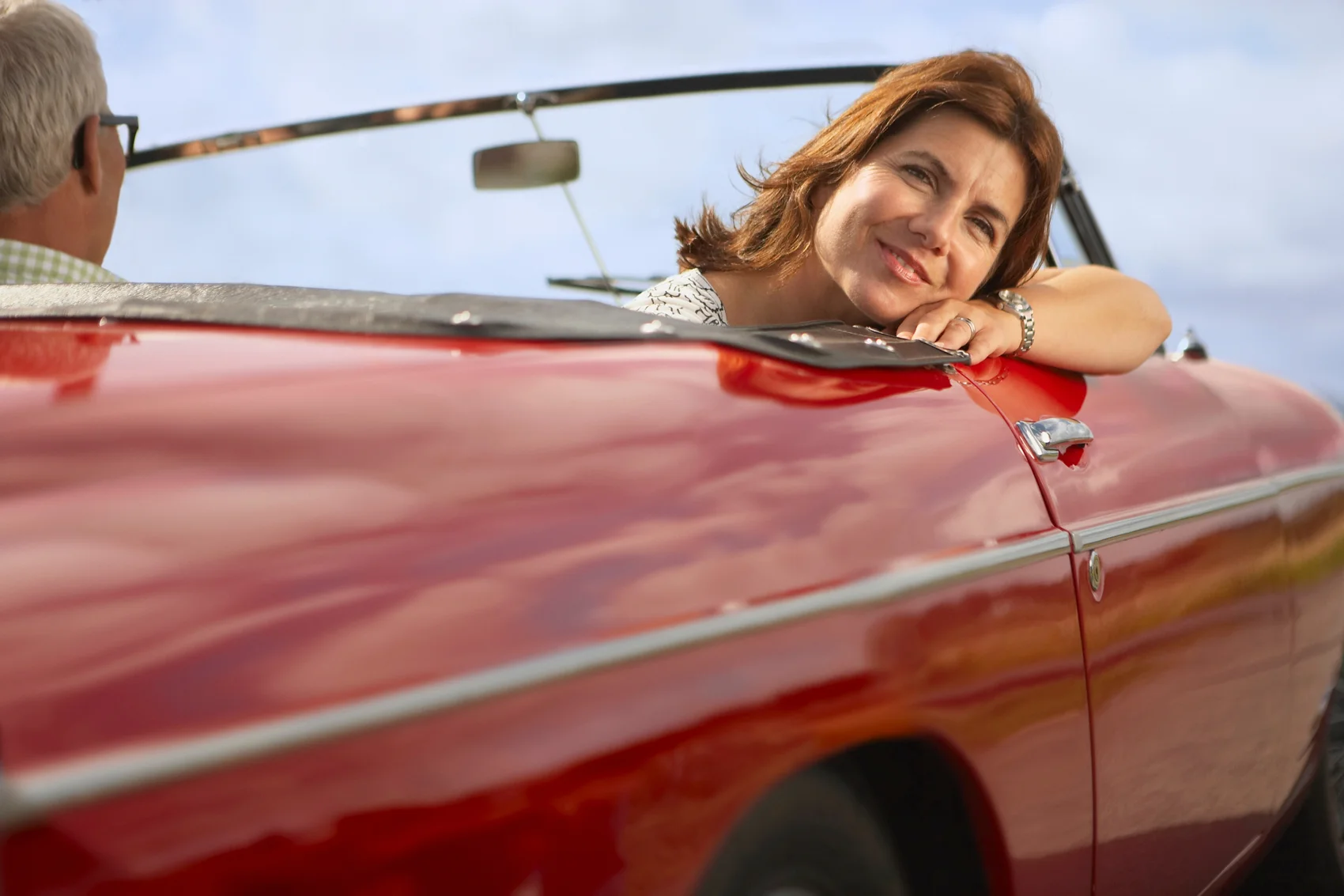 Couple in a sports car headed for overseas car shipping